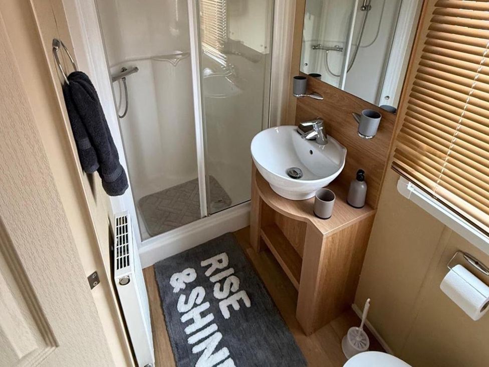 A bathroom with a shower, sink, and toilet at 2-Bed Caravan, Sleeps 6 w/ Parking, No Pass Needed