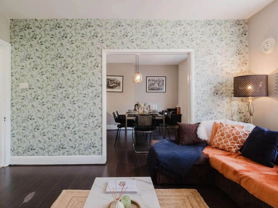 A living room with a sofa and dining area at Licatas Apartment Cirencester Cotswolds Sleeps 6