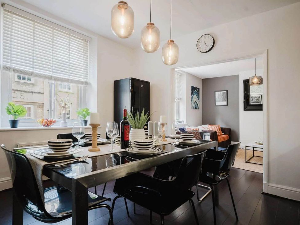 A dining room with a table set for dinner at Licatas Apartment Cirencester Cotswolds Sleeps 6