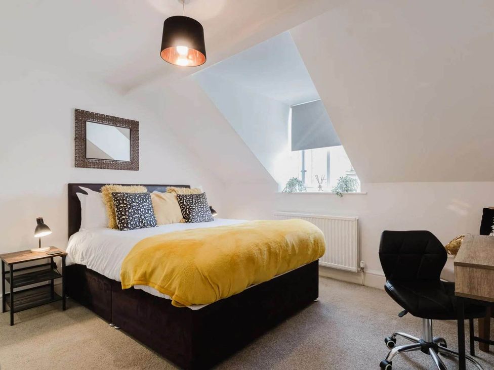 A bedroom with a bed and desk at Licatas Apartment Cirencester Cotswolds Sleeps 6
