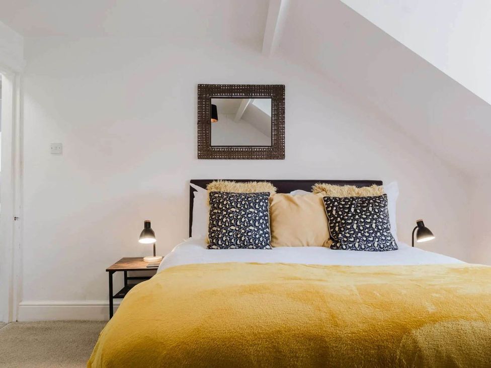 A bedroom with a bed and a mirror at Licatas Apartment Cirencester Cotswolds Sleeps 6