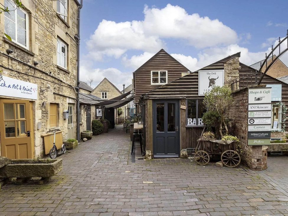 A courtyard with shops and café at Licatas Apartment Cirencester Cotswolds Sleeps 6