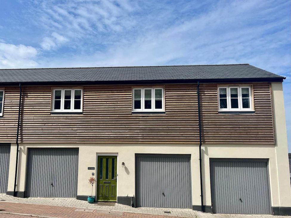 A house with a green door and multiple garage doors at Apartment Sleeps 4 with Parking in Chagford