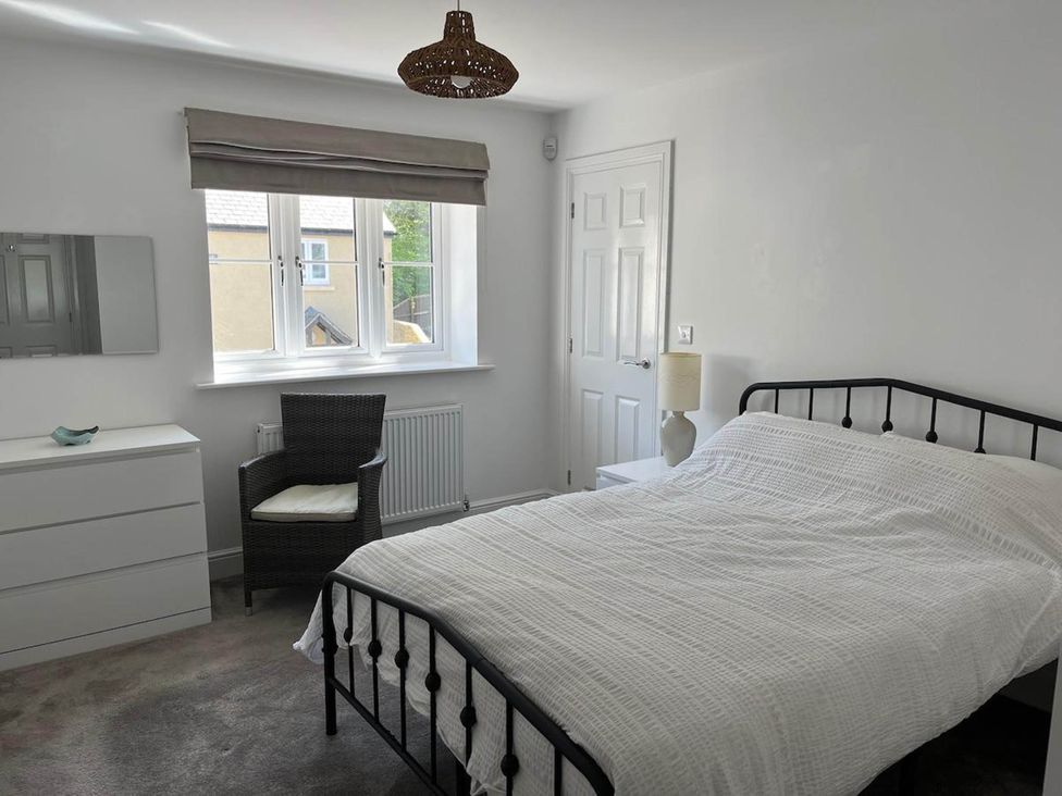 A bedroom with a bed and a chair at Apartment Sleeps 4 with Parking in Chagford