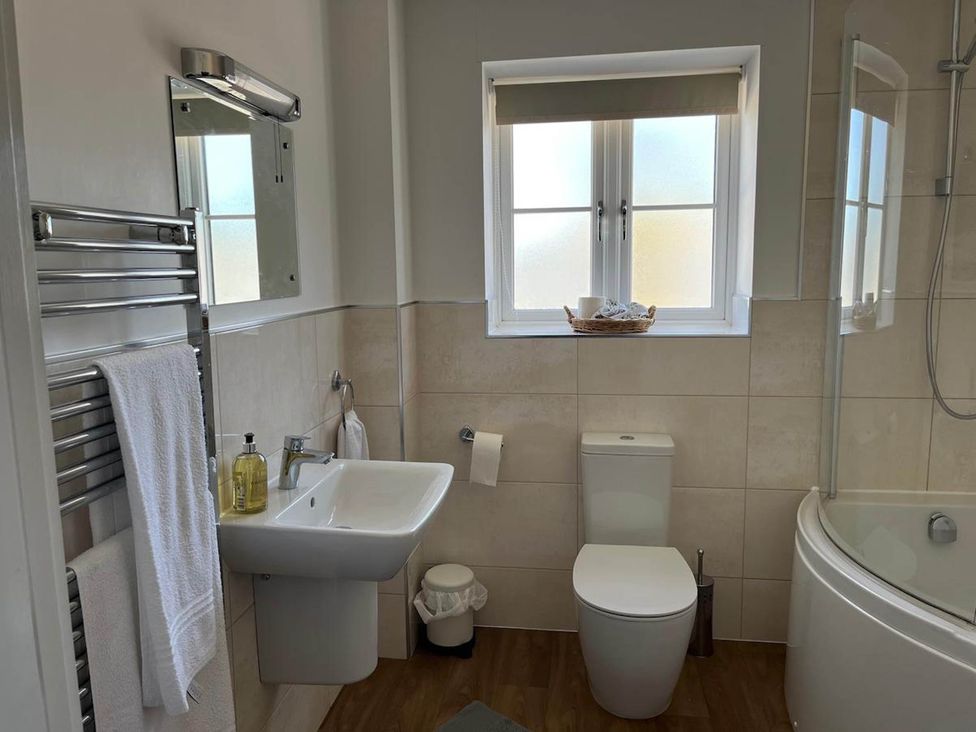 A bathroom with a sink, toilet, and bathtub at Apartment Sleeps 4 with Parking, Chagford