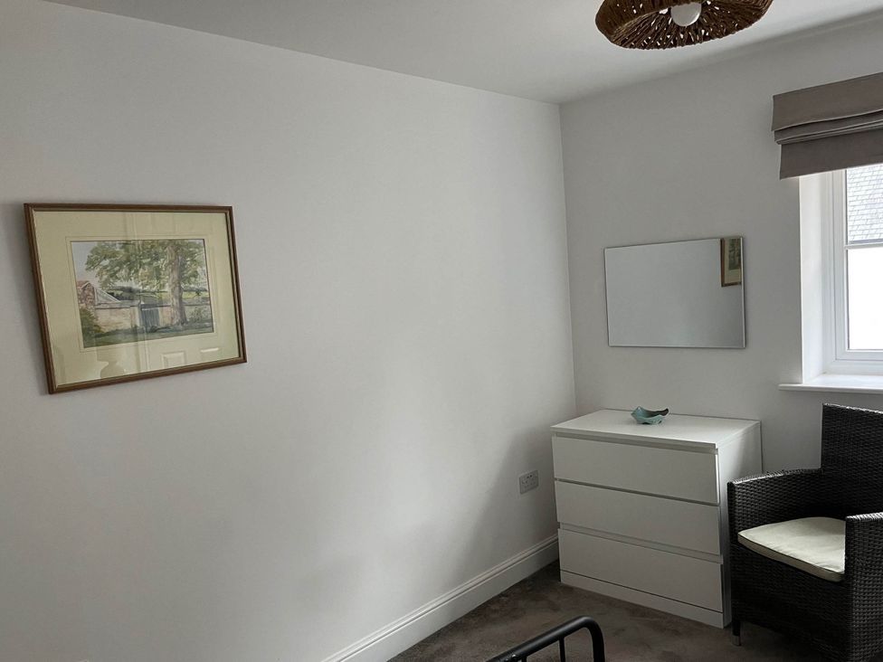 A bedroom with a drawing on the wall and a dressing table at Apartment Sleeps 4 with Parking Chagford