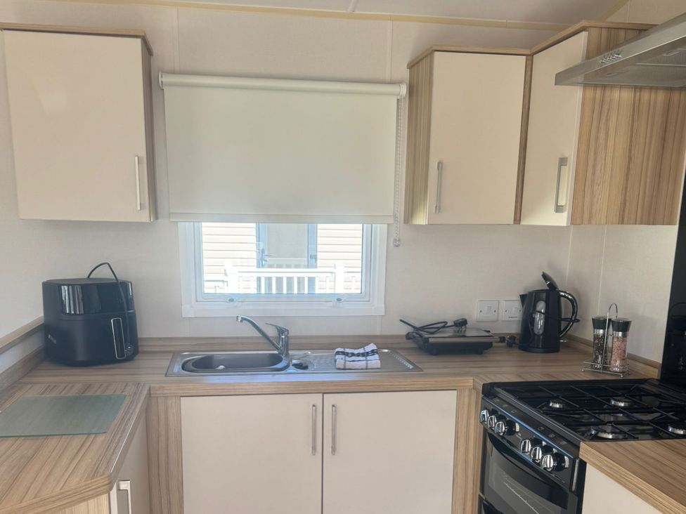 A kitchen with a sink and appliances at Caravan - Sleeps 6 - Parking in Lossiemouth