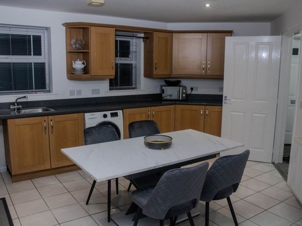 A kitchen with cabinets and a dining table at House Sleeps 5 with Garden and Parking 