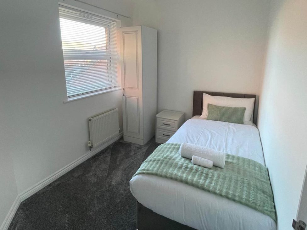 A bedroom with a single bed and wardrobe at House Sleeps 5 with Garden and Parking