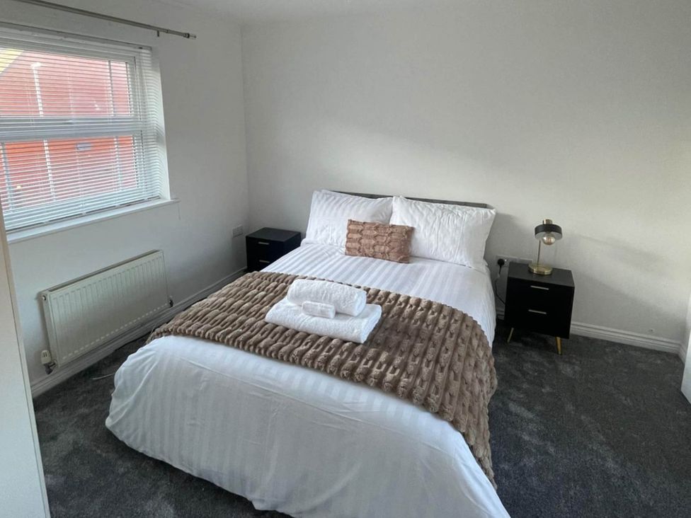 A bedroom with a bed and bedside table at House Sleeps 5 with Garden and Parking