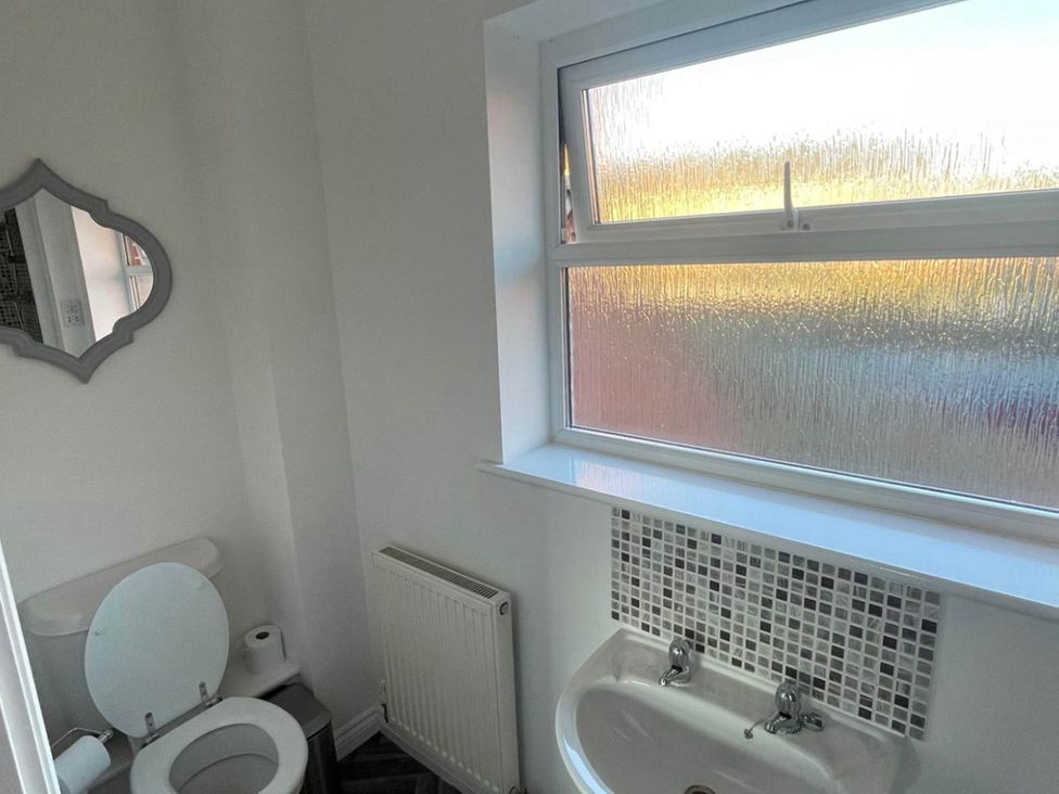 A bathroom with a toilet and sink at House Sleeps 5 with Garden and Parking