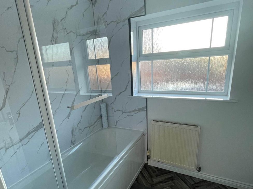 A bathroom featuring a bathtub and shower enclosure at House Sleeps 5 with Garden and Parking
