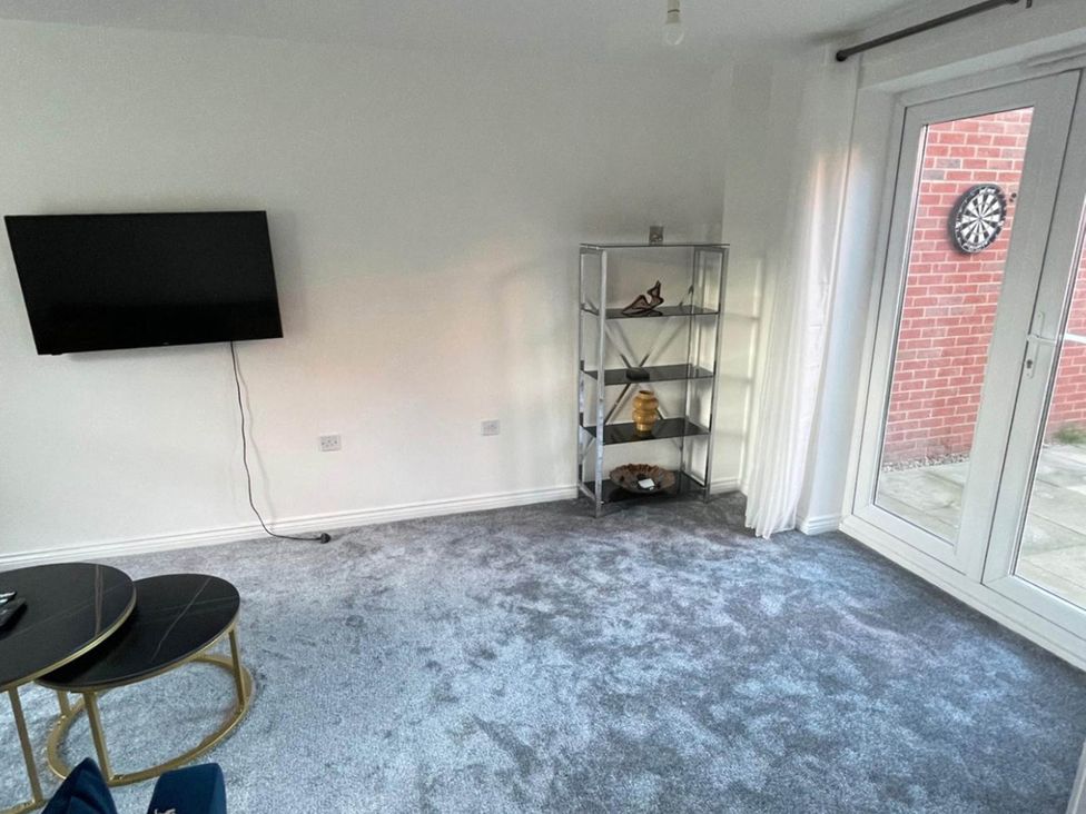 A living room with a television and a shelf at House Sleeps 5 with Garden and Parking