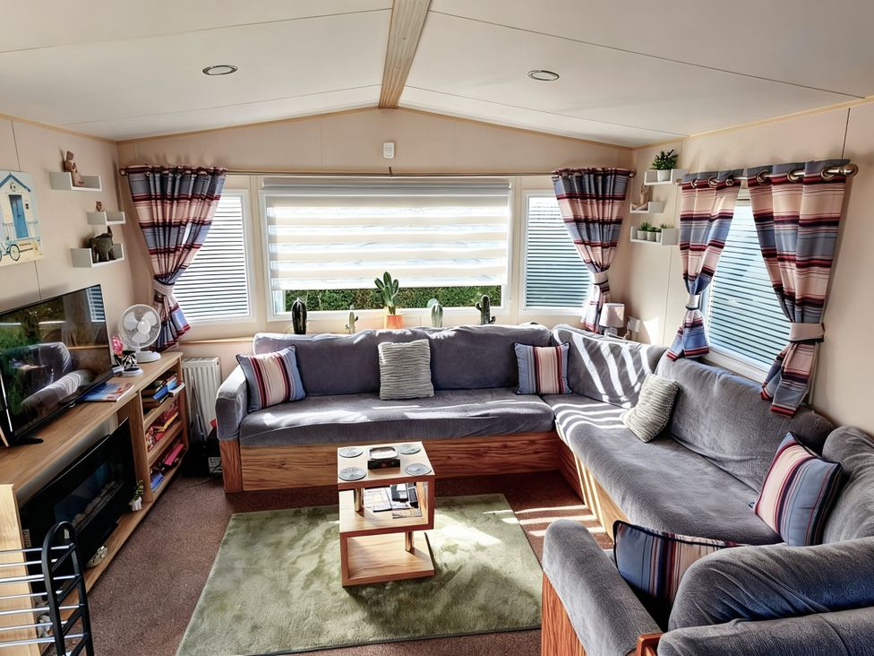A living room with a sofa and television at D&T Caravan Hire Southview Holiday Park Skegness