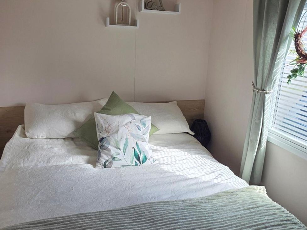 A bedroom with a bed and pillows at D&T Caravan Hire Southview Holiday Park Skegness