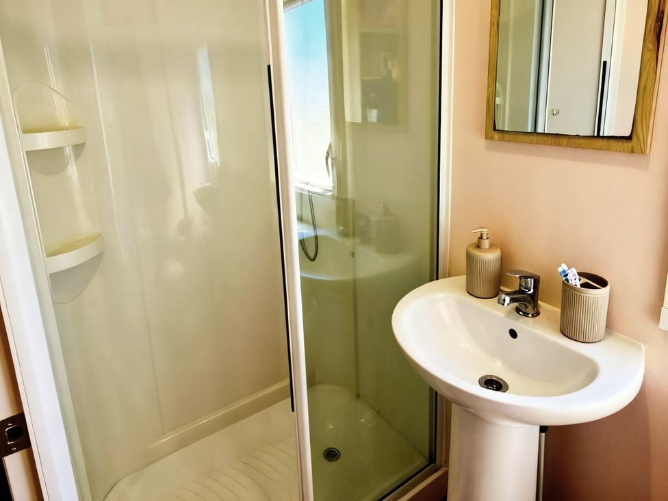 A bathroom with a shower and wash basin at D&T Caravan Hire Southview Holiday Park Skegness