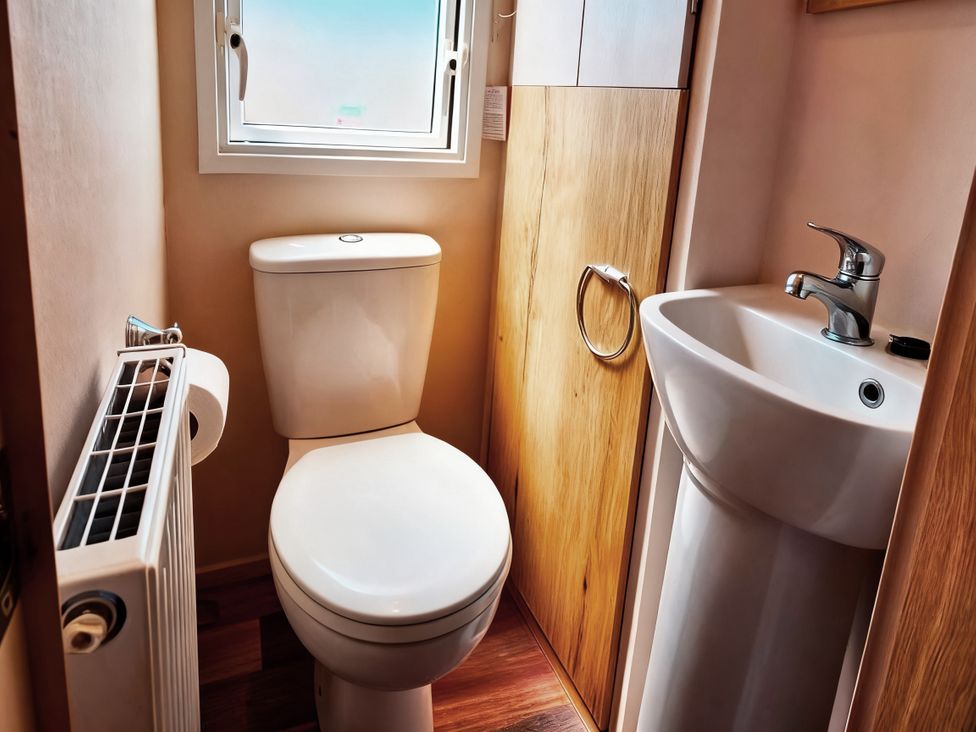 A bathroom with a toilet and sink at D&T Caravan Hire Southview Holiday Park Skegness