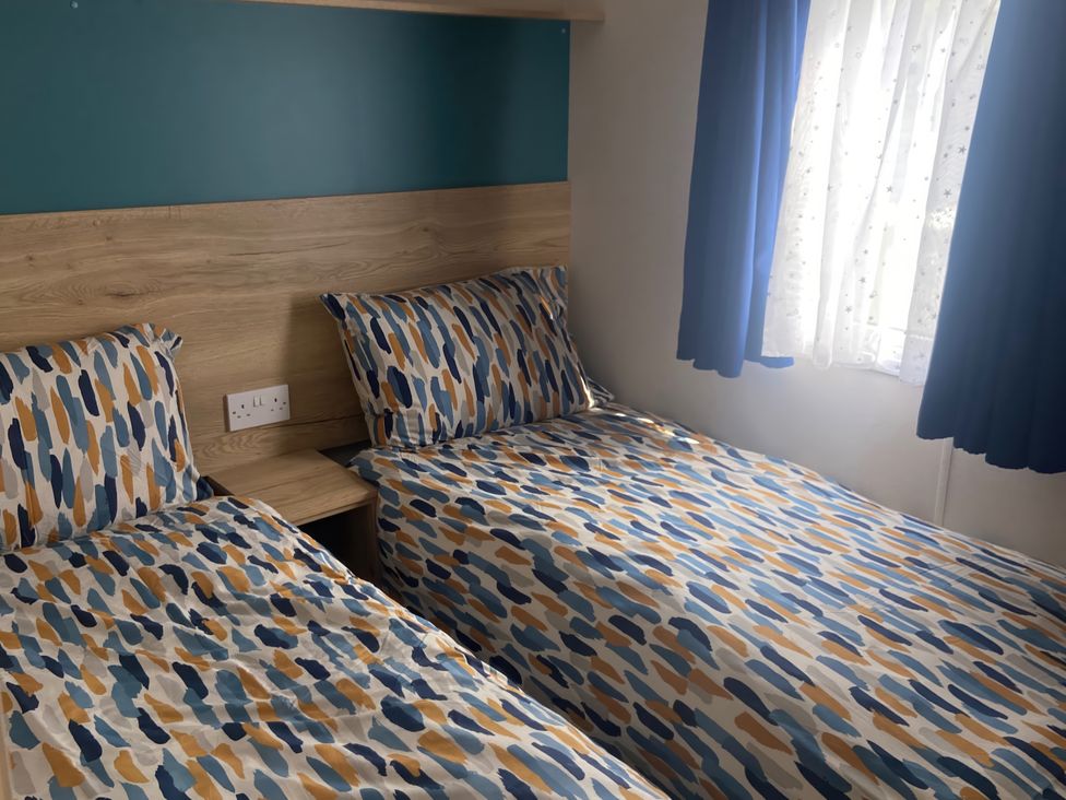 A bedroom with two beds and a window at Coworth Deluxe Cabin with Garden