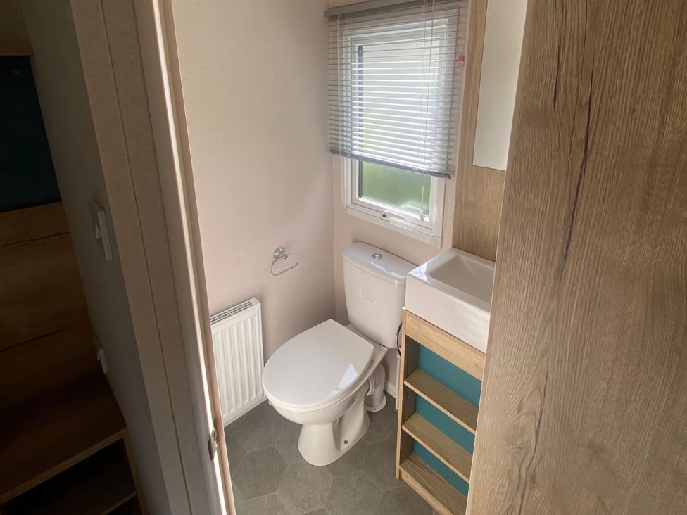 A bathroom with a toilet and sink at Coworth Deluxe Cabin with Garden