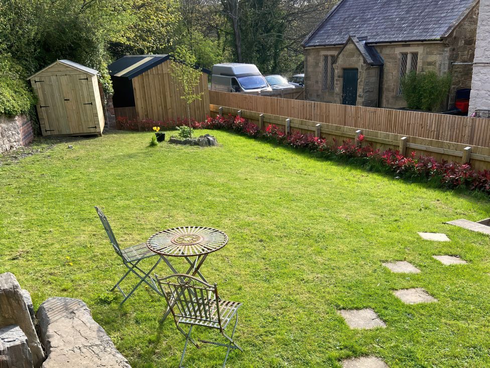 A garden with a table and chairs at Cozy Cabin Retreat in Newtown