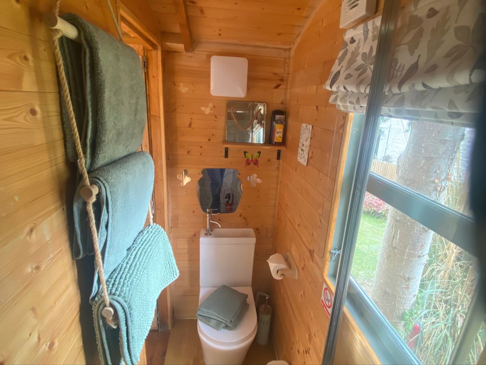 A bathroom with a toilet and mirror at Cozy Cabin Retreat in Newtown