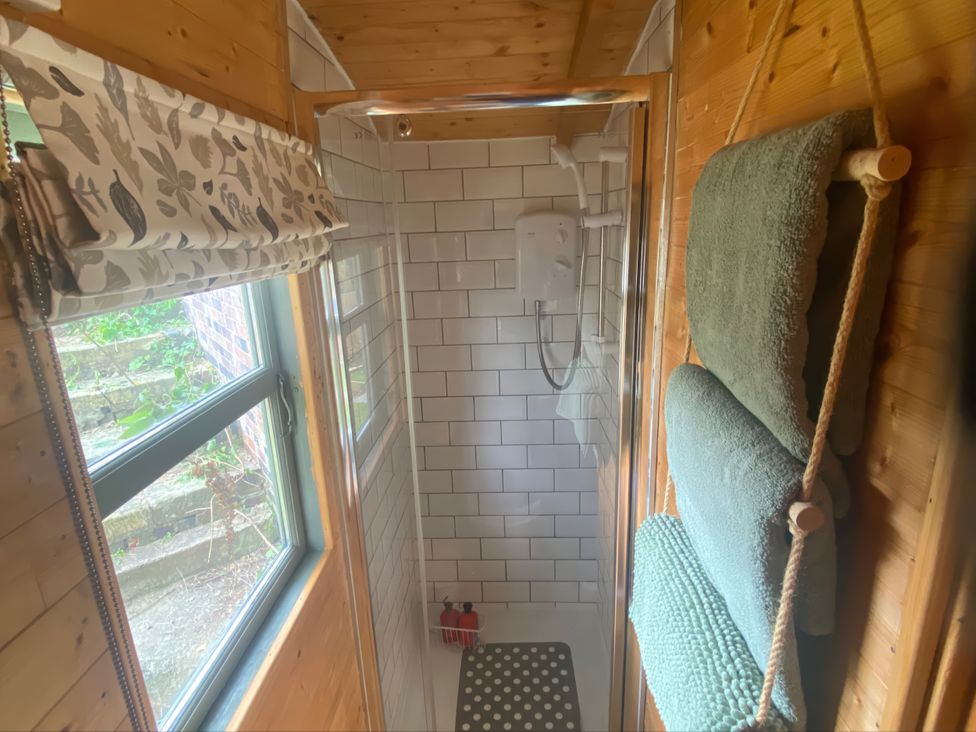 A bathroom featuring a shower with tiles and towels at Cozy Cabin Retreat in Newtown