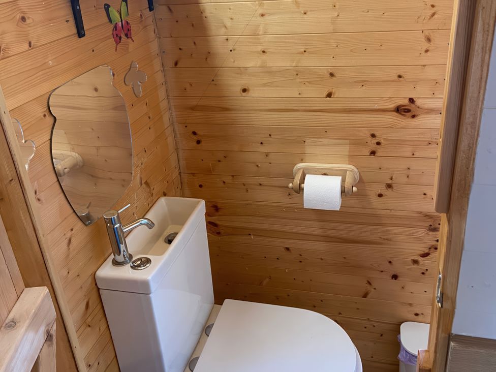 A bathroom with a toilet and sink in Cozy Cabin Retreat in Newtown
