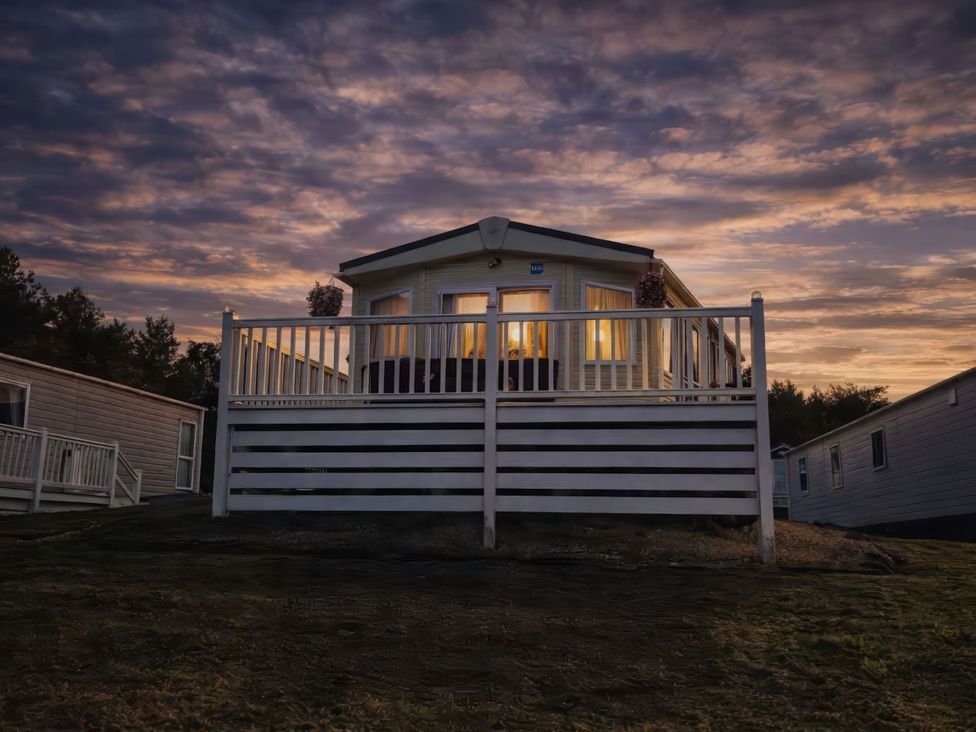 A caravan with a deck and railing at Caravan Sleeps 6 with Sea Views and Parking, Ayr
