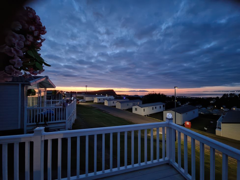 A view from a balcony overlooking houses and the sea at Caravan Sleeps 6 with Sea Views and Parking in Ayr