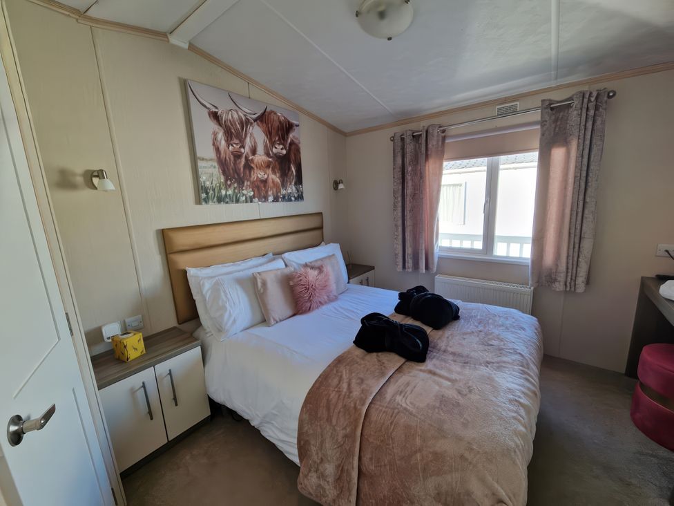 A bedroom with a bed and nightstand at Caravan Sleeps 6 with Sea Views and Parking in Ayr