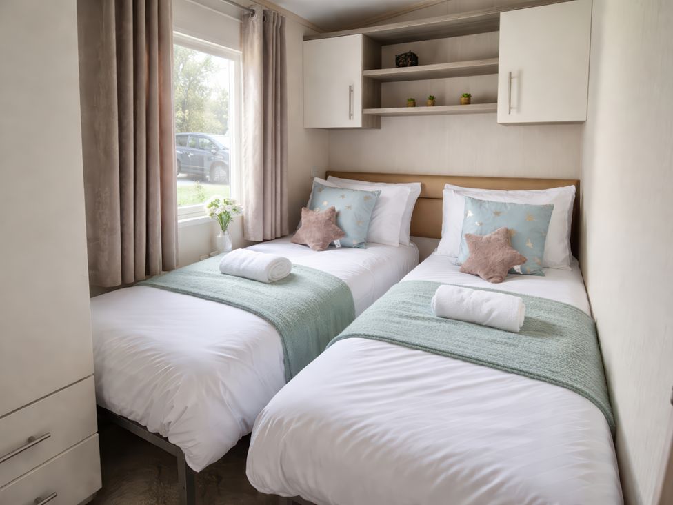 A bedroom with two beds and a window at Caravan Sleeps 6 with Sea Views and Parking Ayr