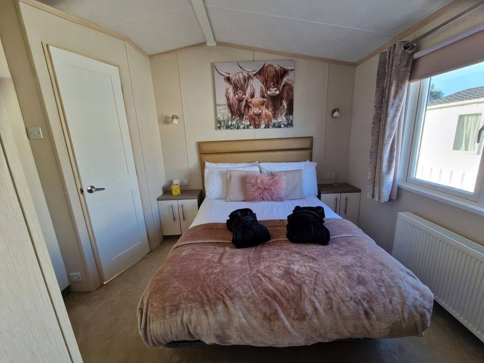 A bedroom with a bed and wall art at Caravan Sleeps 6 with Sea Views and Parking Ayr