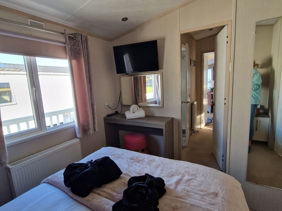 A bedroom with a bed and television at Caravan Sleeps 6 with Sea Views and Parking in Ayr