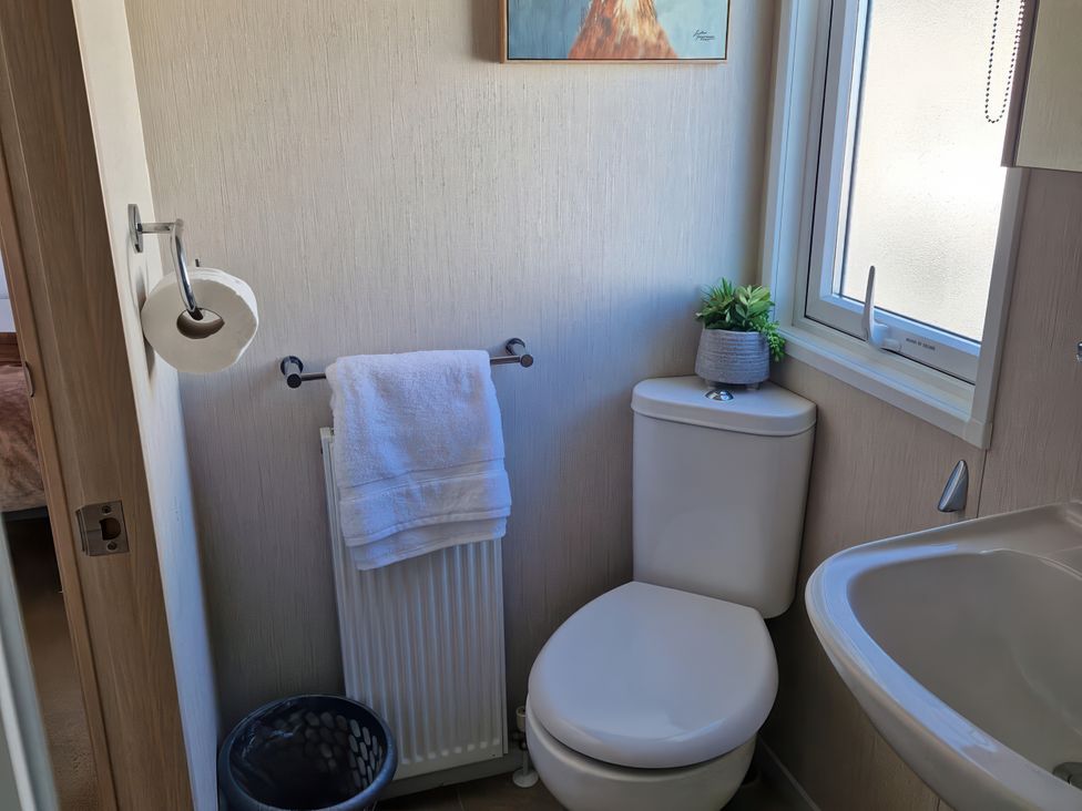 A bathroom with a toilet and a sink at Caravan Sleeps 6 with Sea Views and Parking in Ayr