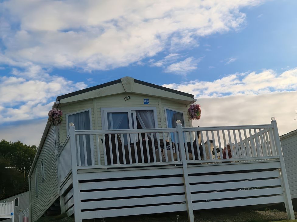 A mobile home with a deck and flowers in Ayr