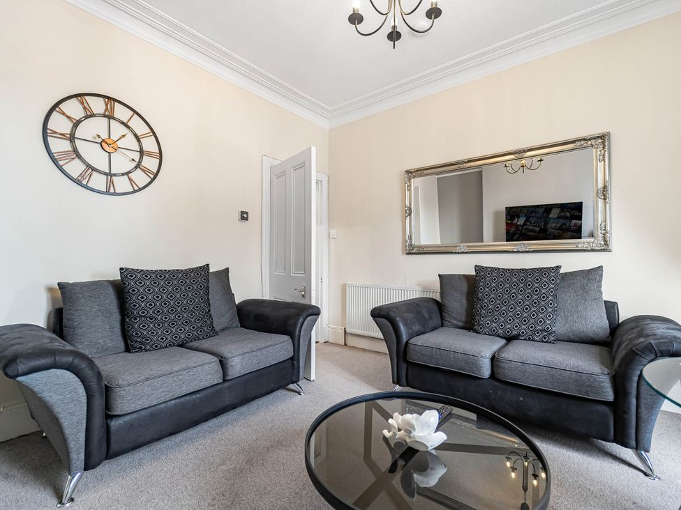A living room with sofas and a clock at Central Aberdeen flat Holburn St workspace parking, Aberdeen