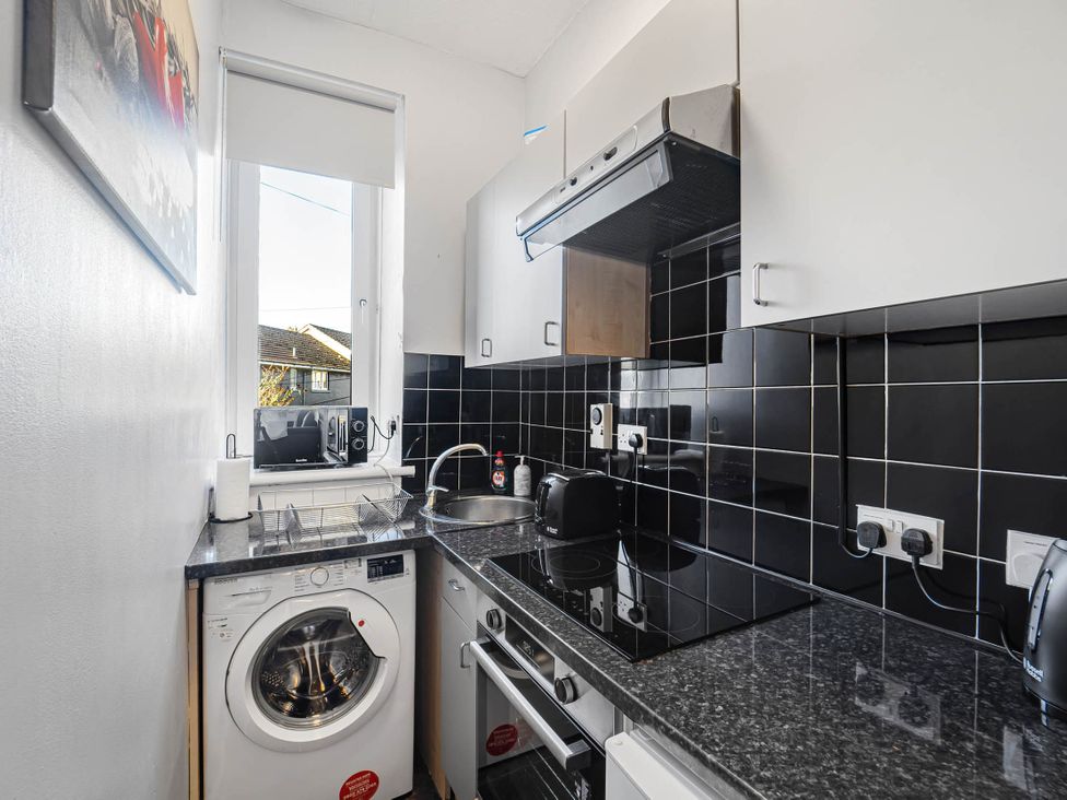 A kitchen with a washing machine and a sink at Central Aberdeen flat Holburn St workspace parking, Aberdeen