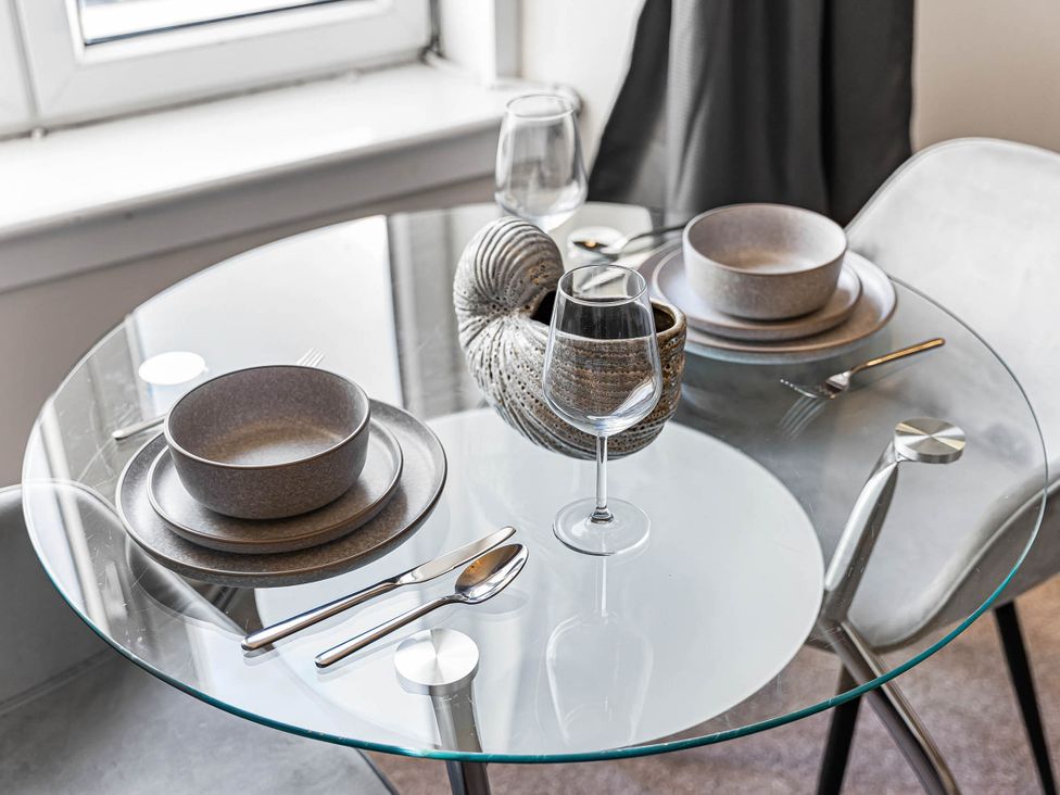 A dining table set with dishes and a wine glass at Central Aberdeen flat Holburn St workspace parking, Aberdeen