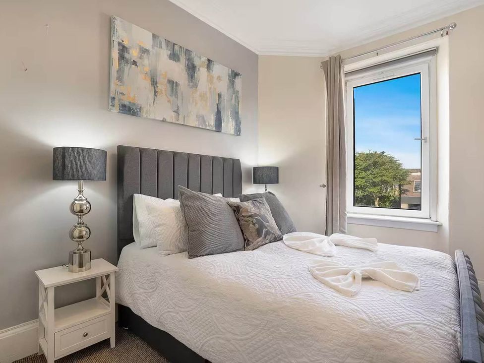 A bedroom with a bed and bedside table at Central Aberdeen flat Holburn St workspace parking, Aberdeen
