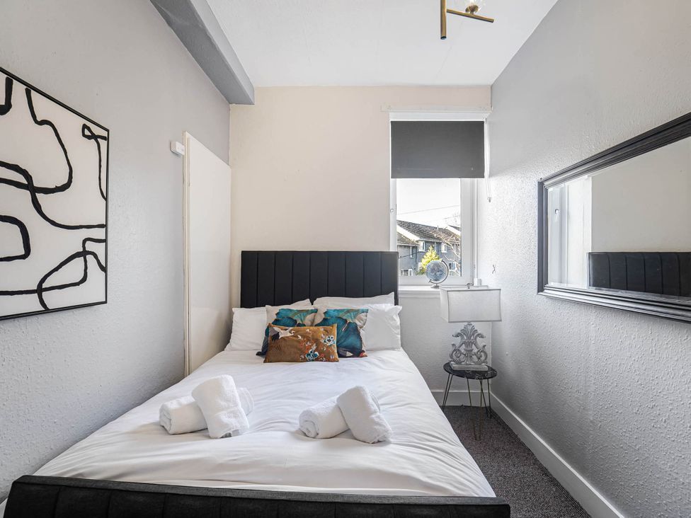 A bedroom with a bed, lamp, and window at Central Aberdeen flat Holburn St workspace parking Aberdeen