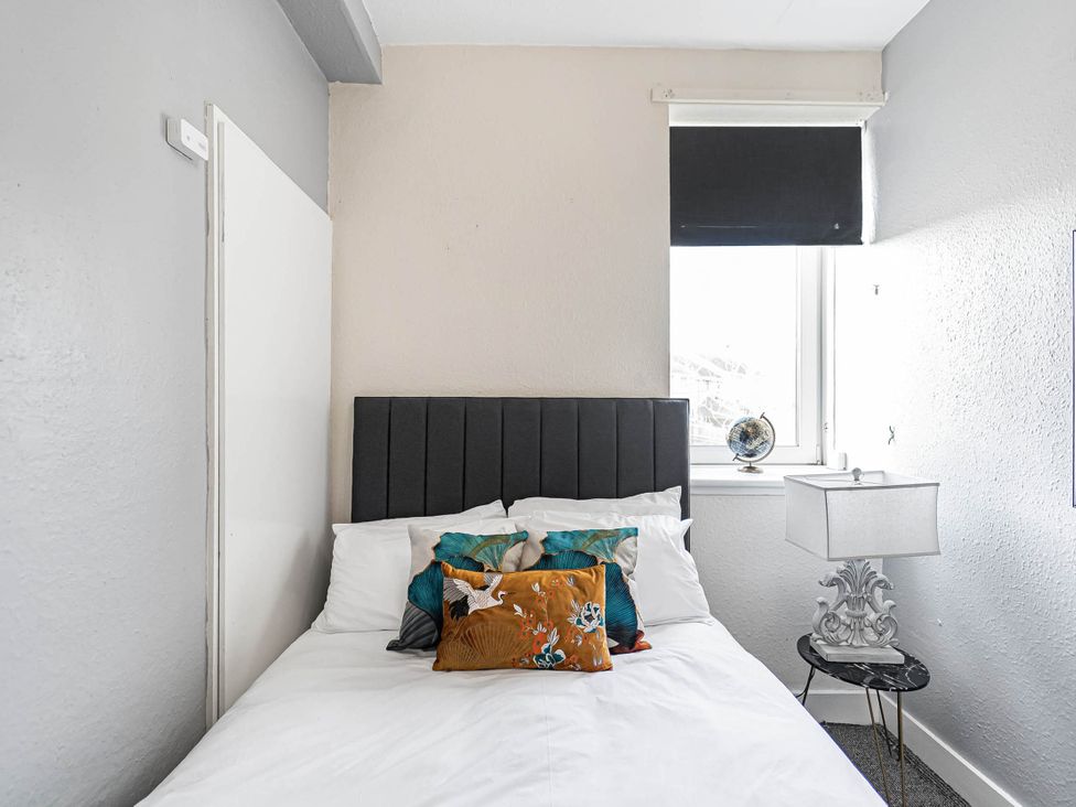A bedroom with a bed and lamp at Central Aberdeen flat Holburn St workspace parking, Aberdeen