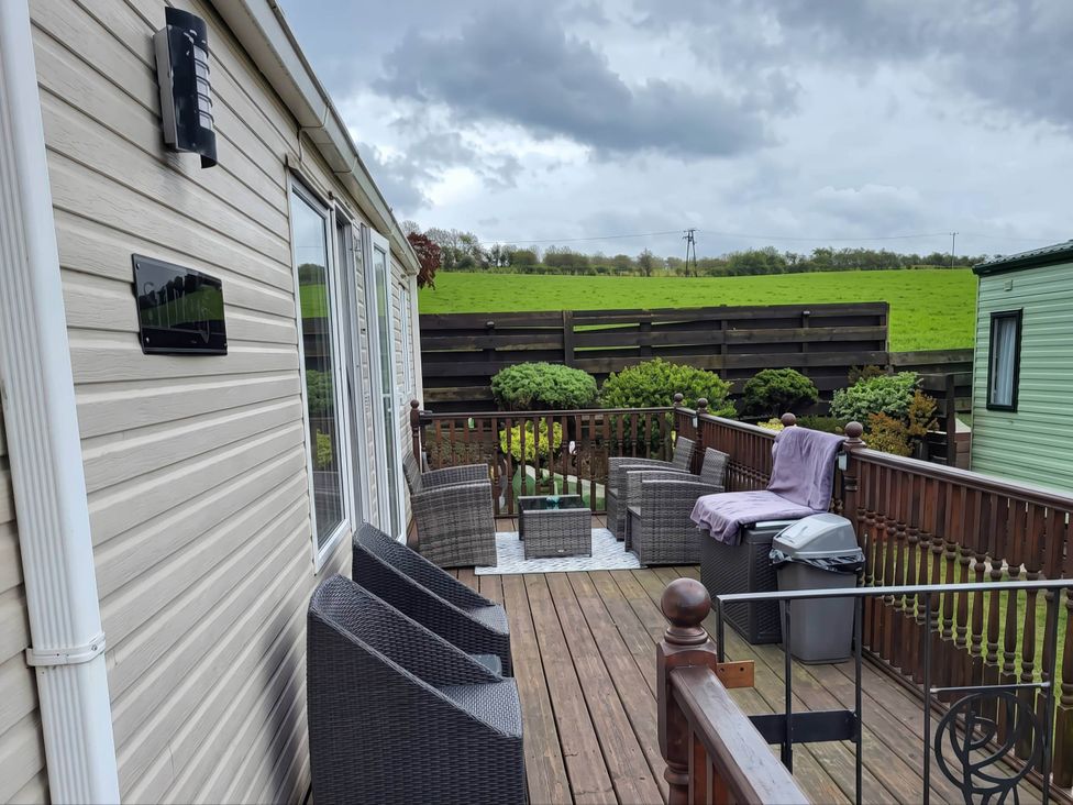 A patio with outdoor furniture and a grill at BandR Turnberry Escape Scotland in Girvan