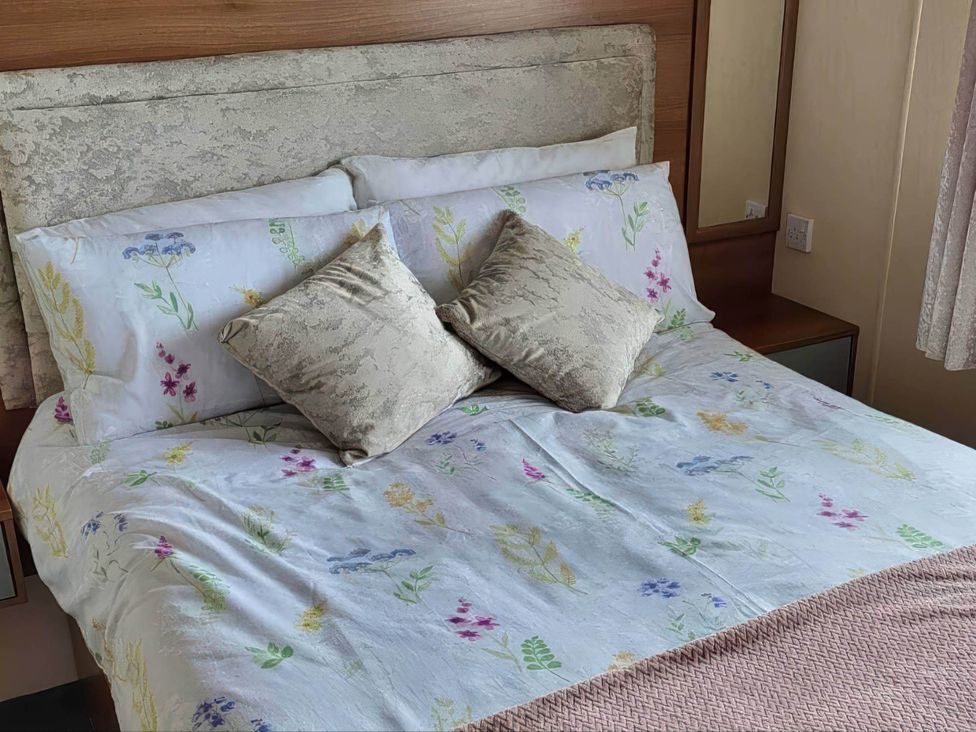 A bed with pillows and cushions at BandR Turnberry Escape Scotland in Girvan
