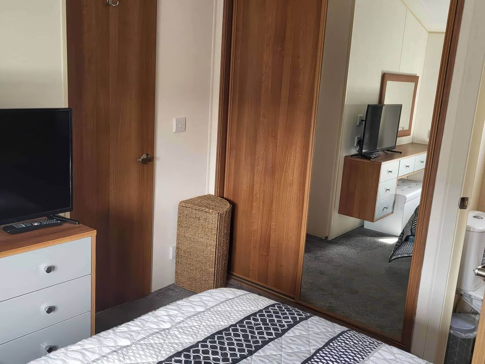 A bedroom with a television and drawers at BandR Turnberry Escape Scotland in Girvan