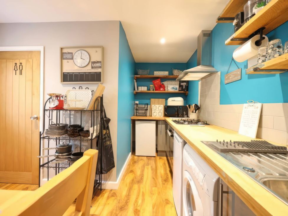 A kitchen with appliances and shelves at Rural 2 double bedrooms Barn Mill Meece near Eccleshall