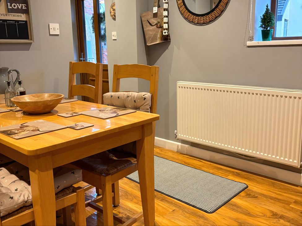 A dining room with a wooden table and chairs at Rural 2 double bedrooms Barn Mill Meece near Eccleshall