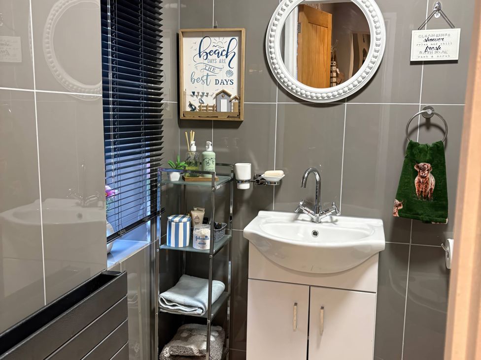 A bathroom with a sink, mirror, and towel at Rural 2 double bedrooms Barn in Mill Meece near Eccleshall