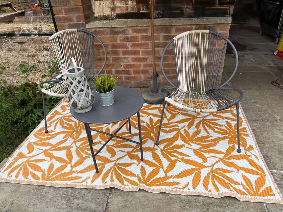 An outdoor seating area with two chairs and a table at Rural 2 double bedrooms Barn in Mill Meece near Eccleshall