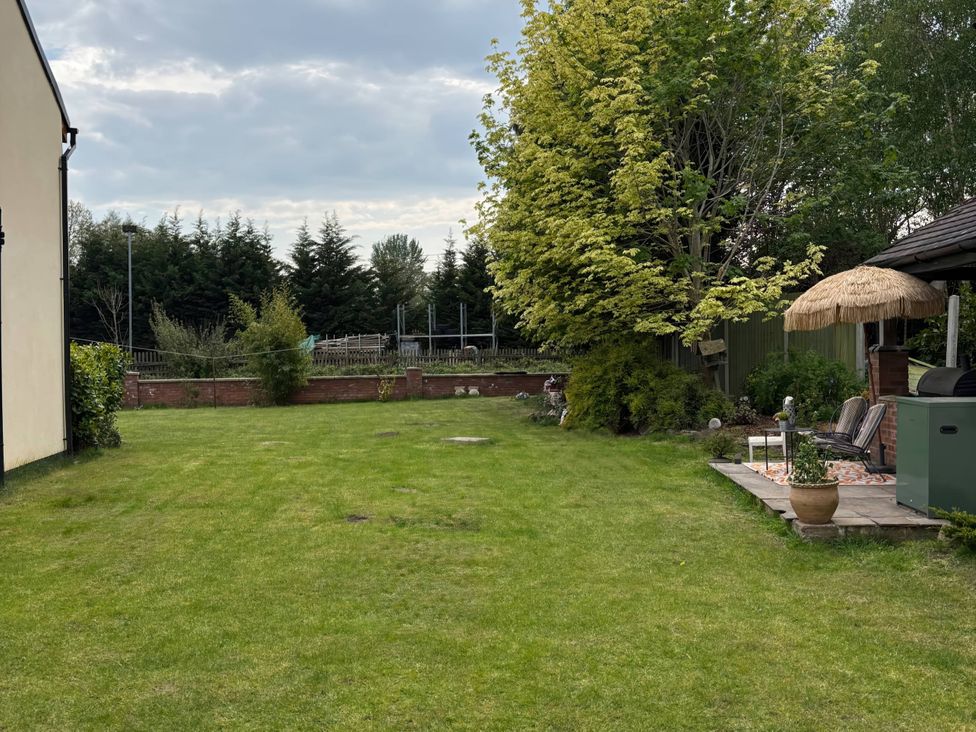 A garden with grass, trees, and patio furniture at Rural 2 double bedrooms Barn Mill Meece near Eccleshall