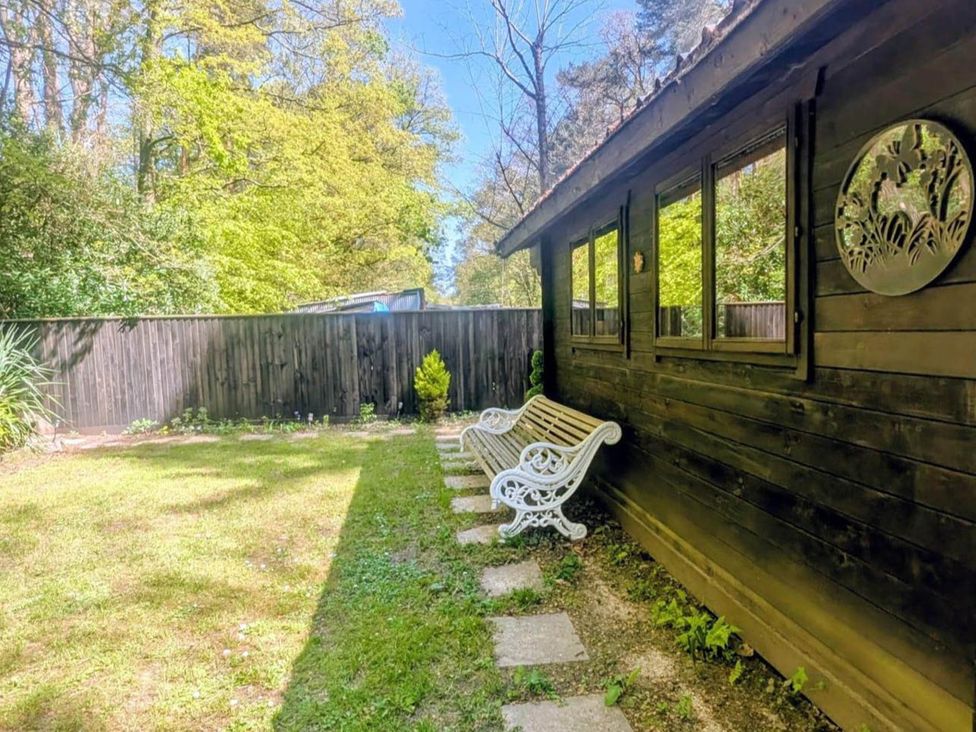 A garden with a bench and pathway at Forest Cabin Retreat-Sleeps 2-Garden, Wifi, Trails in Alderholt